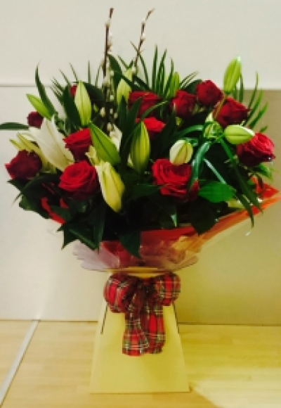12 Roses & White Lilies - 12 red roses with white lilies in one of our presentation boxes with food and water. Includes local delivery.